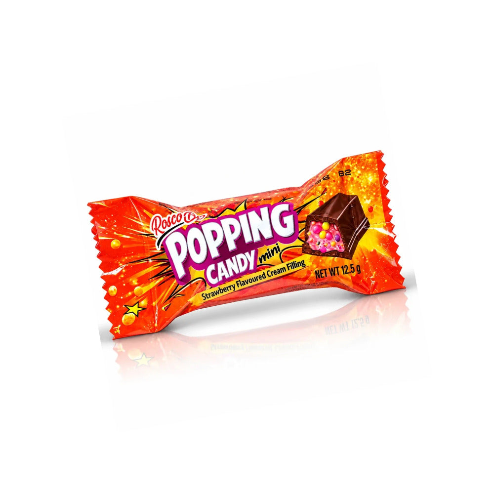 A single wrapped candy bar on a clean white background with a soft reflection underneath. The wrapper is bright orange-red with yellow starburst graphics and large white and purple text reading 'Popping Candy' and 'Strawberry Flavoured Cream Poppy.