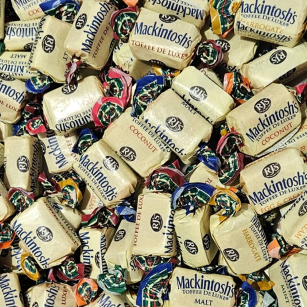 A close-up pile of individually wrapped Mackintosh's Toffee Delights candies, showing cream-colored wrappers with blue branding and colorful foil seals in various flavors.