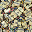 A close-up pile of individually wrapped Mackintosh's Toffee Delights candies, showing cream-colored wrappers with blue branding and colorful foil seals in various flavors.
