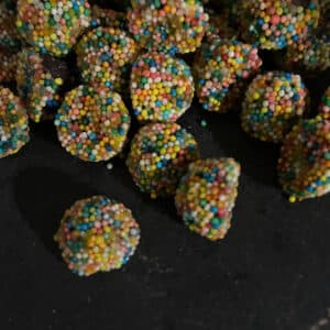 Licorice Delights aniseed balls with sugar beads on a dark stone background