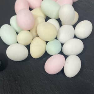 pastel coloured sugared almonds on a grey stone background